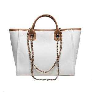 Minimalist white canvas tote bag with brown leather trim and chain shoulder strap