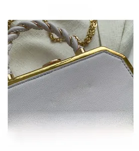 Close-up of pebble leather shoulder bag with golden FASHION & BAG logo and chain detail