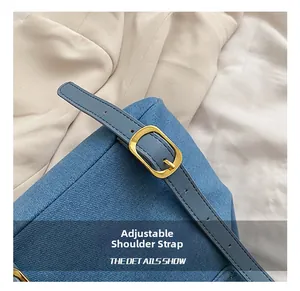 Detail of light blue quilted denim bag featuring adjustable strap with gold metal buckle