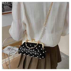 Détail d'un sac de soirée matelassé noir orné de perles avec bandoulière chaîne dorée