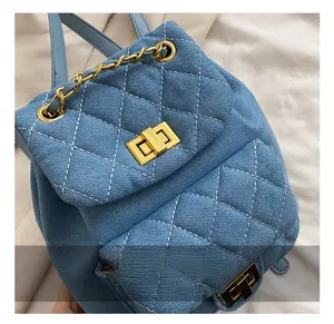 Detail of light blue quilted denim mini backpack with gold twist lock and chain handle