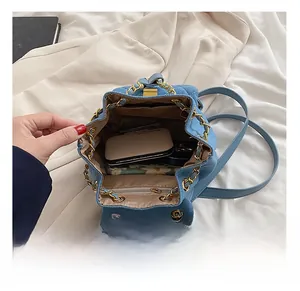 Internal view of blue denim quilted mini backpack showing zipper pocket and storage capacity
