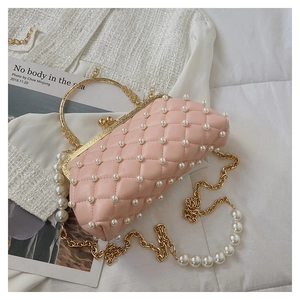 Détail du sac matelassé rose avec perles blanches, poignée dorée et bandoulière chaîne