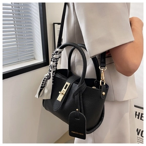 Detail of black lychee leather tote bag with houndstooth silk scarf and gold lock hardware