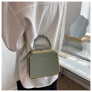 Detailed view of sage green textured leather box bag with gold metal frame and chain