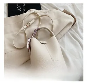 Detail of off-white lychee texture bucket bag with floral silk scarf on handle