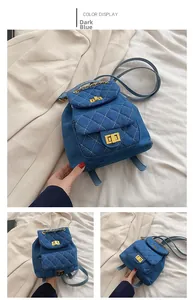 Detail of deep blue denim mini backpack with quilted pattern and gold chain hardware