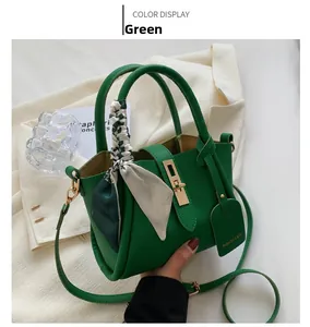 Detail of green lychee leather tote bag with a floral silk scarf and gold metal clasp