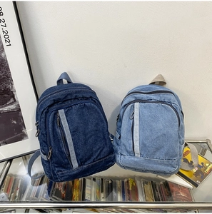 Detailed macro view of retro washed denim mini backpacks in dark blue and light blue colors