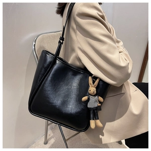Vue détaillée du grand sac cabas en cuir noir avec un pendentif lapin pied-de-poule