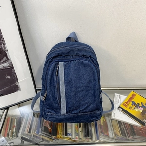 Compact washed denim backpack in navy blue with light blue webbing for casual travel