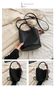 Detail of black bucket bag featuring lychee texture leather and a decorative silk scarf