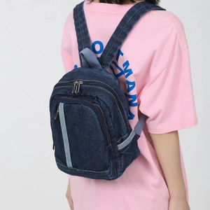 Deep blue washed denim mini backpack for women featuring adjustable straps and pockets