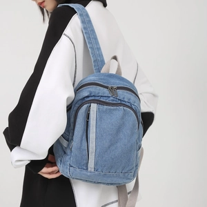 Minimalist light blue washed denim backpack for women with front zipper pocket and straps