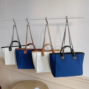 Four large capacity canvas tote bags with chain straps in multiple neutral colors