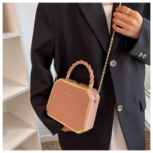 Detailed shot of a dusty pink hexagonal crossbody bag with golden hardware and chain strap