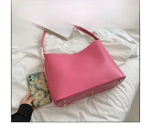 Detailed view of the large pink tote bag featuring protective gold-toned bottom rivets