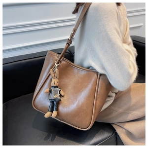 Détail d'un grand sac cabas marron en similicuir avec un charmant lapin sur la bandoulière