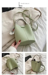 Detail of mint green lychee pattern bucket bag with silk scarf handle and slim strap