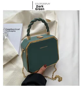 Detail of green octagonal handbag with twisted handle and golden metal frame
