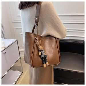 Sac cabas en cuir marron avec un joli pendentif lapin en peluche dans un cadre intérieur