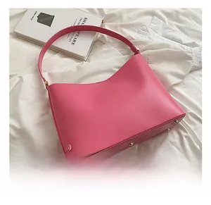 Detailed close-up of pink hobo bag bottom with protective gold metal studs and smooth PU leather