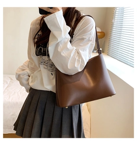 Retro brown leather shoulder bag detail with adjustable strap and metallic gold studs