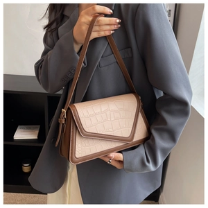 Detail of retro color-block shoulder bag with crocodile texture and V-shaped flap cover