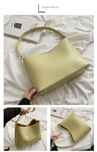 Detailed view of yellow faux leather tote bag with protective gold bottom studs