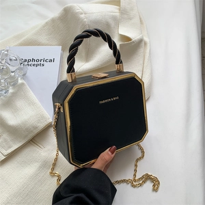 Black octagonal crossbody bag with gold chain and lychee texture in lifestyle setting