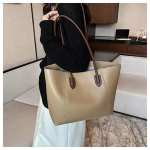 Detail of khaki tote bag showing long brown handles and spacious silver fabric interior