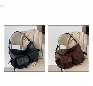 Detail of two large capacity shoulder bags in black and coffee leather with buckle pockets
