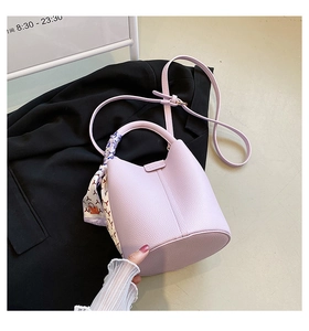Detail of lavender lychee leather bucket bag with decorative printed silk scarf handle