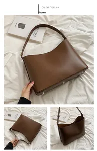 Detail view of brown leather tote bag with protective gold studs and interior closure