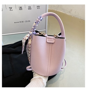 Detail of lavender lychee leather bucket bag with silk scarf and gold hardware