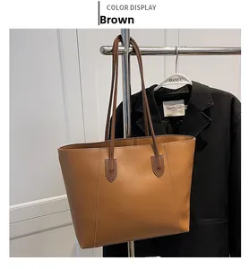 Detail of a large brown tote bag with contrast stitching and professional handle design