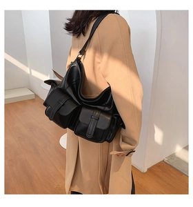 Side view of large black leather tote bag with functional utility front pockets