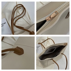 Detail view of beige tote bag features leather handles, zipper, and precise stitching