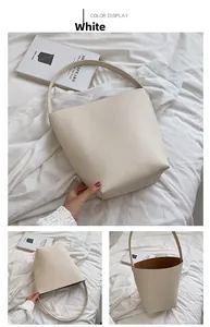 Detail view of white minimalist bucket bag showing leather texture and interior layout
