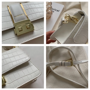 Detail of white crocodile embossed leather handbag with gold buckle and adjustable strap