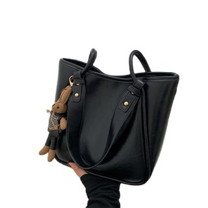 Grand sac cabas en cuir noir avec breloque lapin mignonne sur fond blanc éclatant