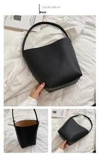 Detailed views of black pebbled leather bucket bag featuring a tan contrast lining