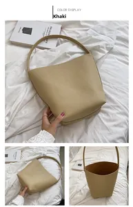 Detail view of khaki bucket bag showing litchi texture leather and spacious interior