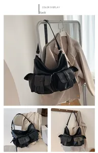 Detail view of black multi-pocket tote bag showing the industrial style and large storage