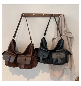 Detail of dual front pockets on brown and black leather tote bags for work