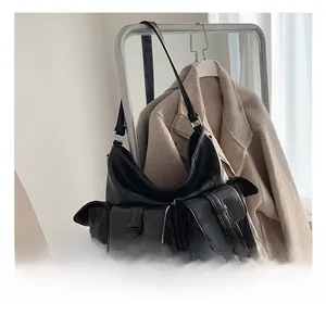 Detail of black faux leather hobo bag featuring functional flap pockets and silver hardware