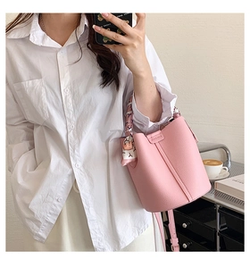 Pink lychee grain bucket bag with a decorative floral silk scarf and metal logo plaque