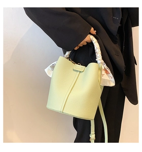 Detail of mint green lychee pattern leather bucket bag with silk scarf handle wrap