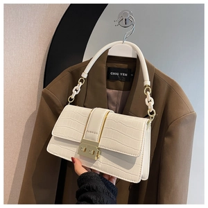 Close-up of white crocodile pattern crossbody bag with a gold fashion buckle and chain handle