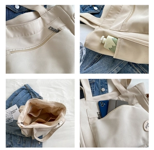 Detailweergave van beige canvas tote met ritsvakken en handige binnenvakken voor opslag